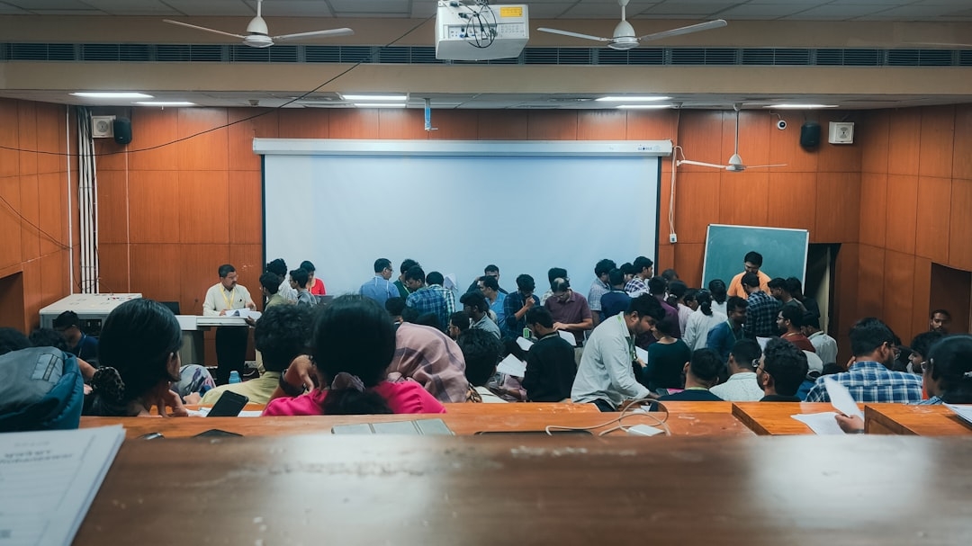 A group of people sitting at a table in front of a projector screen