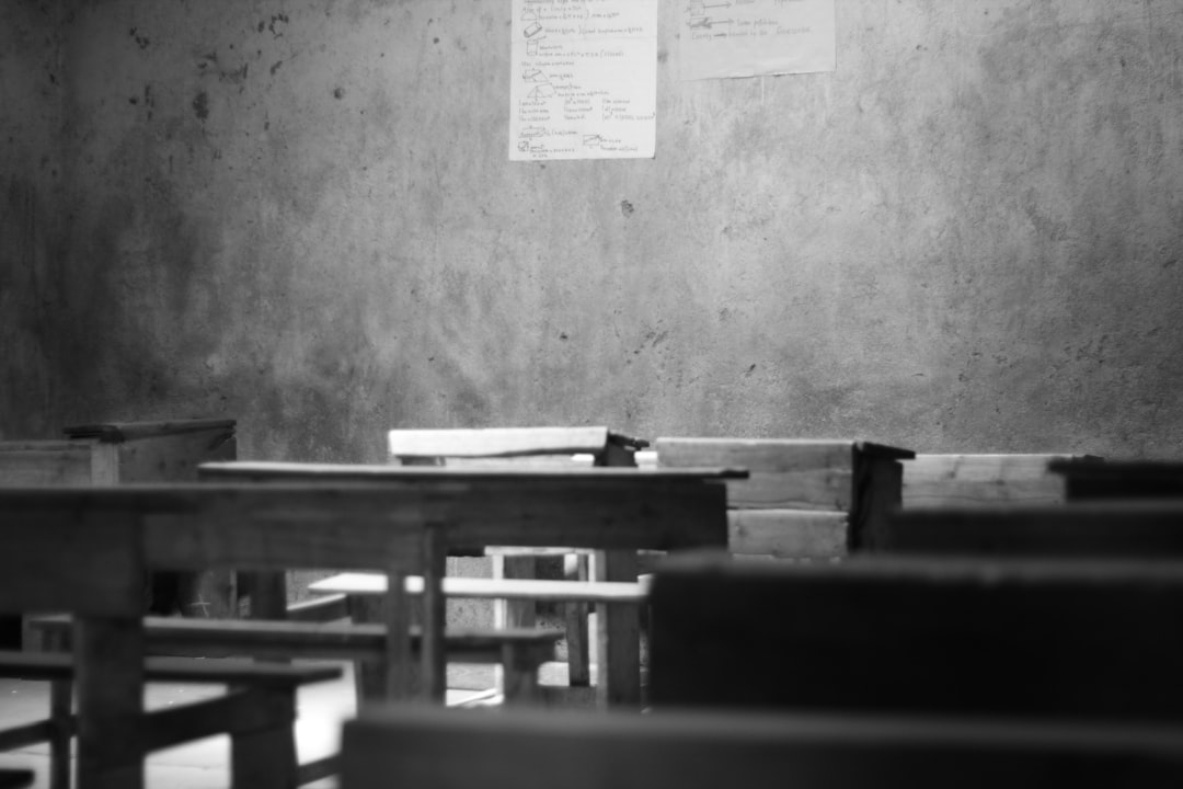 grayscale photography of school desk and board