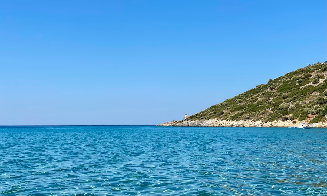 a body of water with a hill in the background