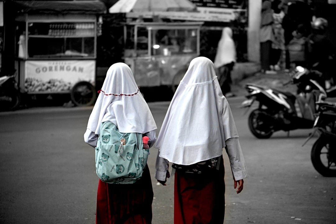 A couple of women walking down a street