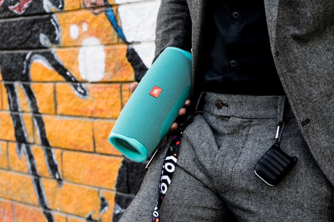 a man in a suit holding a blue speaker