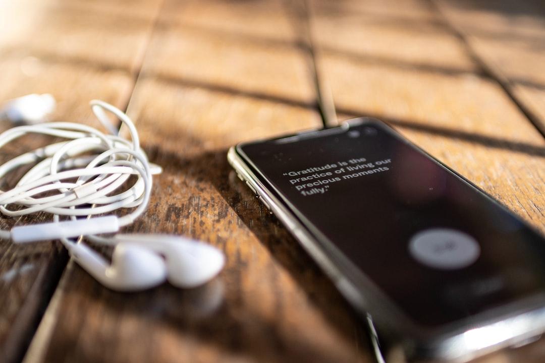 a cell phone and earphones on a wooden table