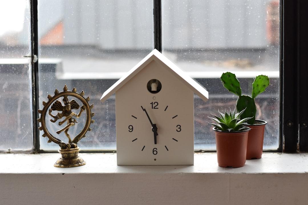 white wooden house analog clock reading 5:55